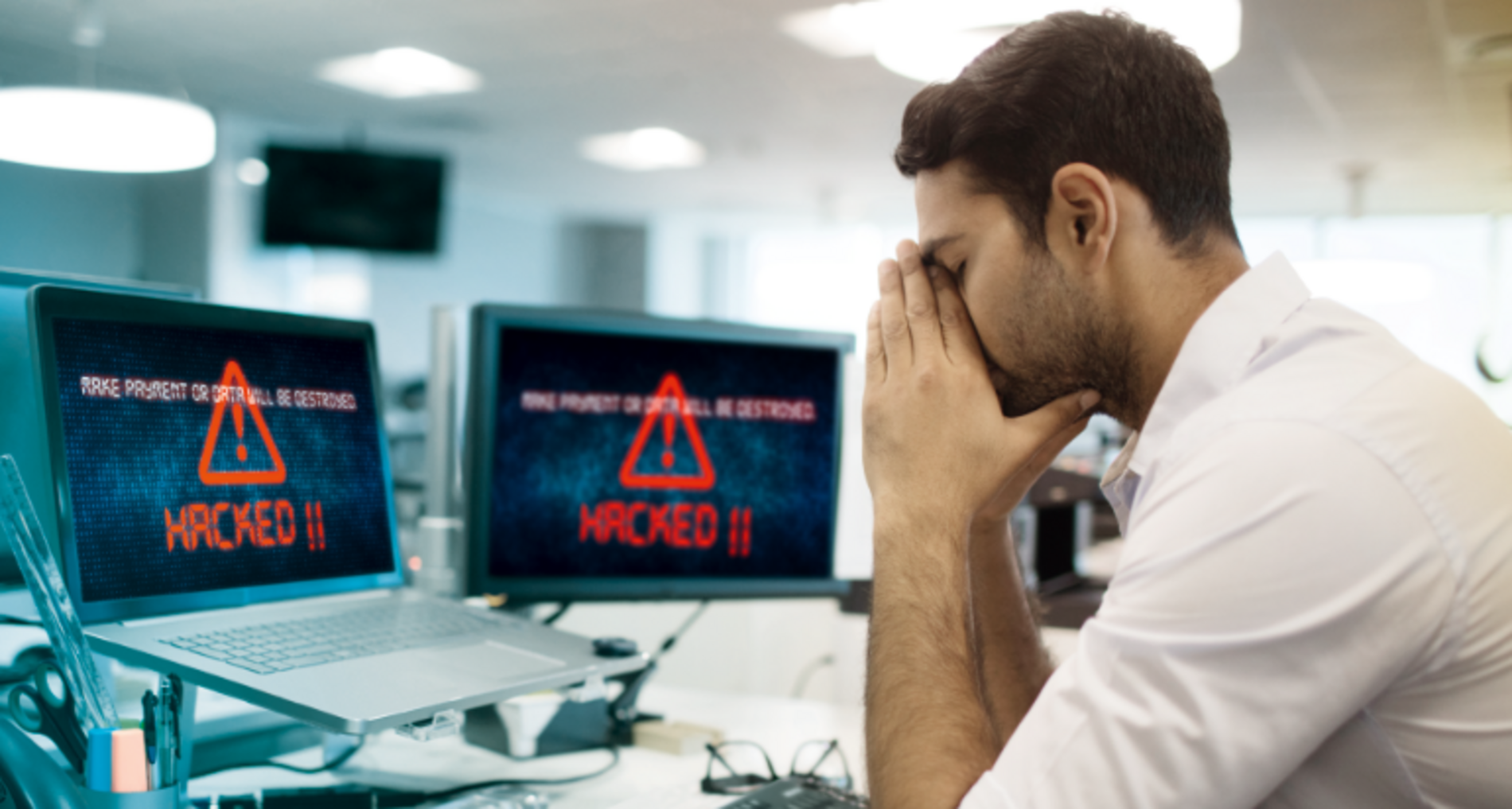 Verzweifelter Mann vor dem Bildschirm da sein Unternehmen gehackt wurde