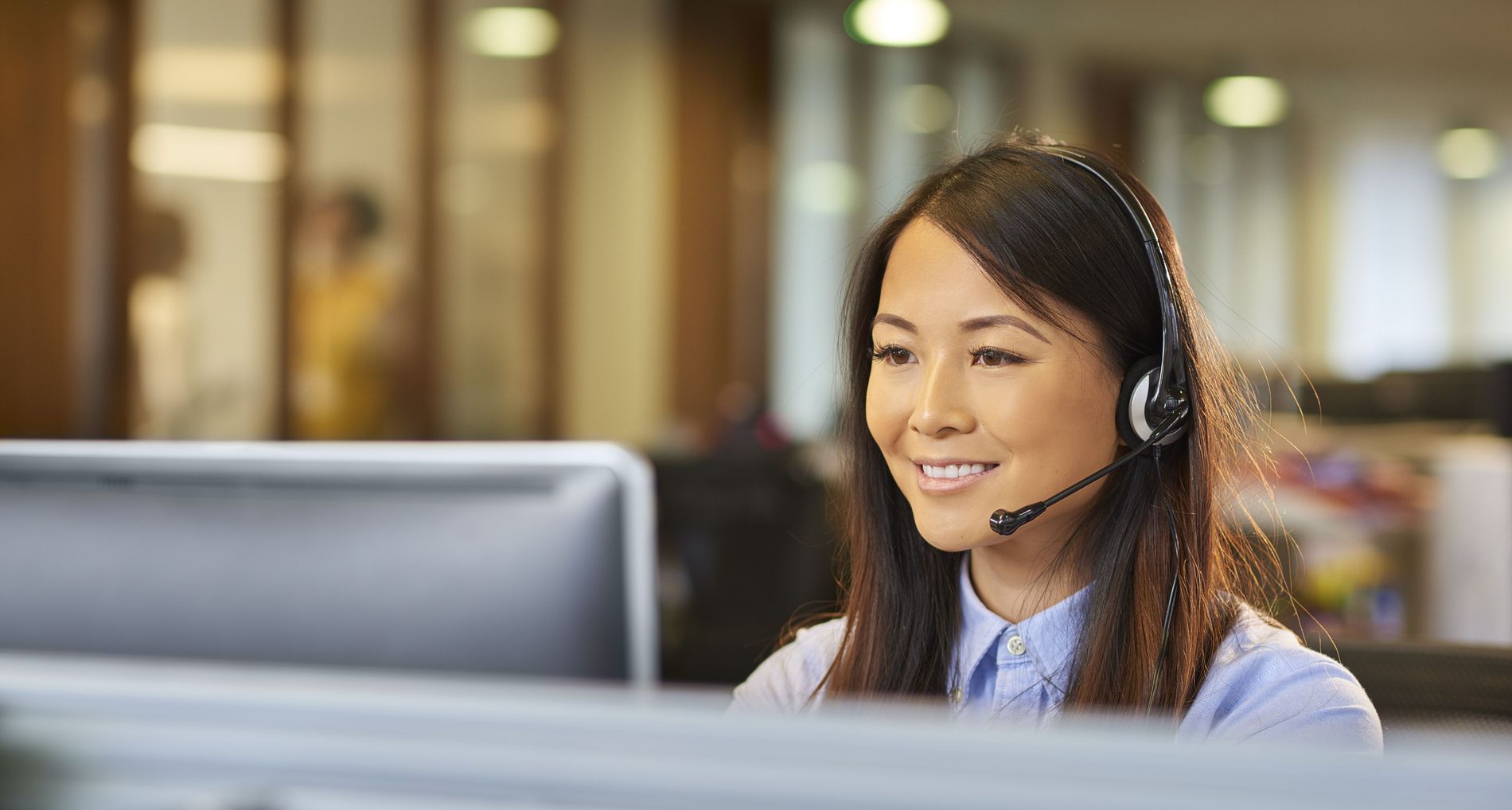 Eine junge Callcenter-Mitarbeiterin begrüsst einen Anrufer