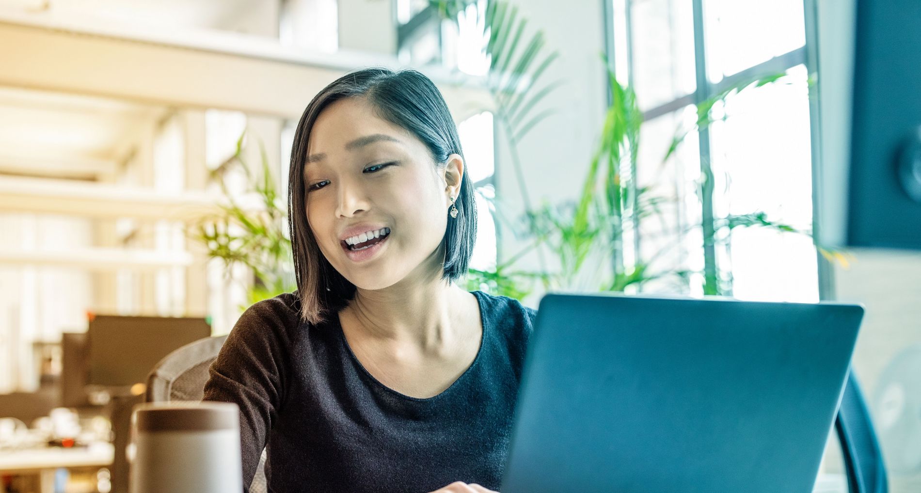 Woman laughs in front of notebook
