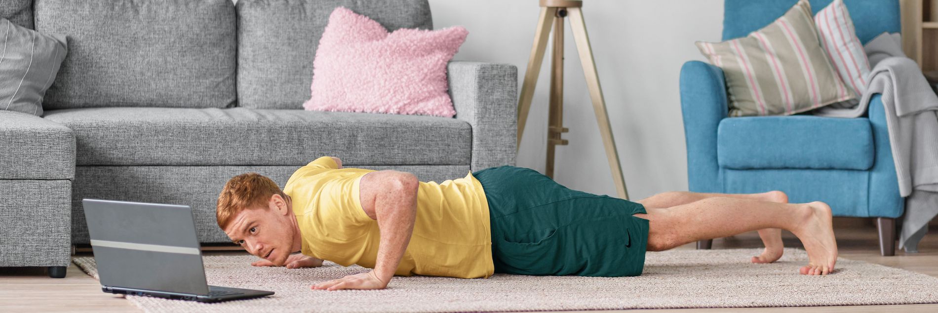 A man trains his fitness at home in front of a laptop with internet from Green.
